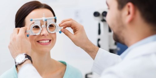 Optician Using a Phoropter Tool on Patient 
