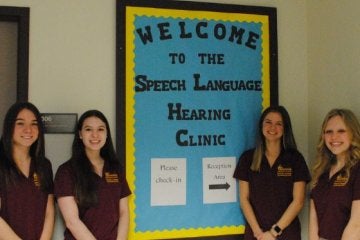 MS Speech-Language Pathology students standing next to a welcome sign
