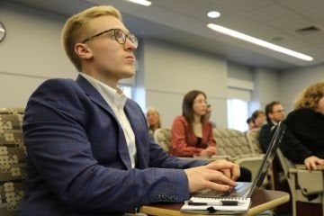 student in a classroom with a laptop