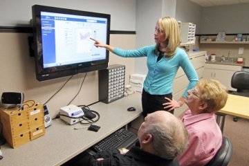 Audiology clinician showing results to patients.