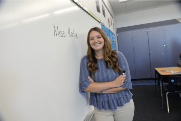 MEd Reading student standing in front of a whiteboard
