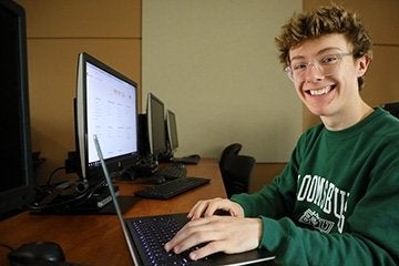 Happy student sitting at the computer completing the FAFSA form
