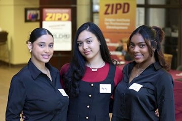 Three female student pose for phot during ZIPD Business Conference in 2025.