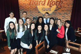 A group of people standing together in front of a brick wall.