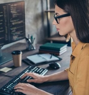 Female computer programmer with dark hair and glasses