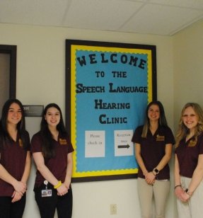 MS Speech-Language Pathology students standing next to a welcome sign