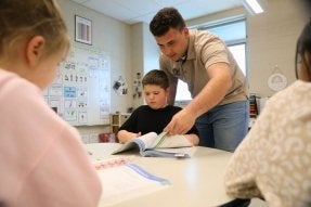 A CU Education major working with a young child during a field experience