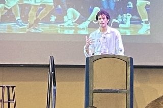 A man standing in front of a projector. 