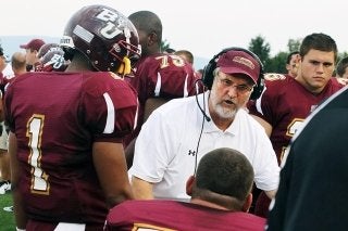 Coach surrounded by football players. 
