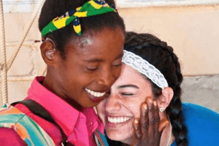 A close up of two ladies hugging. 