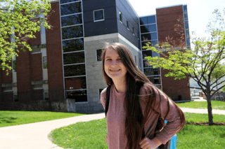A girl standing in front of the school.
