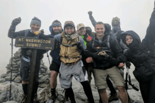 A group of students standing next to a MT. Washington summit sign. 