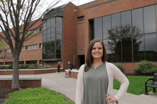A woman standing in front of a building.