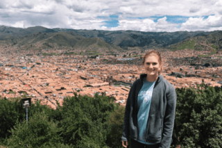 A woman standing high on a mountain.