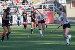 A group of girls playing field hockey.