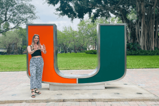 A girl standing in front of a large U. 