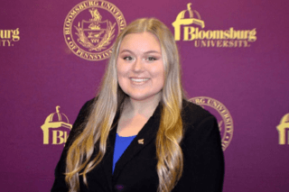 A headshot of a woman in front of a Bloomsburg University background