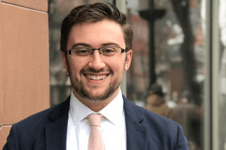 A headshot of a man outside. 