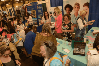 A group of people by a vendor table.