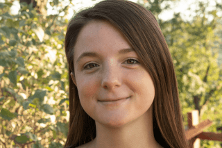 A headshot of a woman outside. 