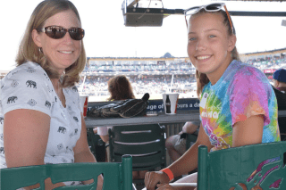 A woman and young teen watch a Lehigh Valley Iron Pigs game from the pavillion