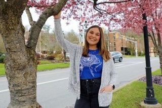 An Honors student at CU-Lock Haven standing on campus with the iconic Bell Tower in the background
