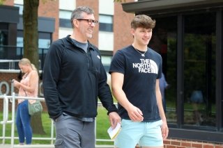 two individuals walk together on campus