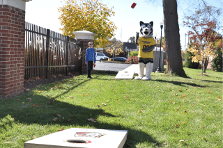 Roongo throwing a cornhole bag at a recent Homecoming Tent Party