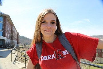A Mansfield student smiles wearing a shirt that says Dream Big