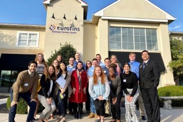 A group of Bloomsburg University students gather in front of the Eurofins facility in the Lehigh Valley during a Husky Career Road Trip