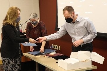 Dr. Carolyn LaMacchia (L) Receives Credential from Jonathan Hedrick (R). Dr. Lisa Stallbaumer-Beishline (C) is the TALE Director