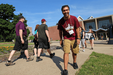 A group of students walking on the side walk. 