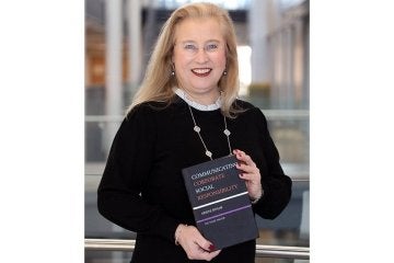A girl holding an award. 