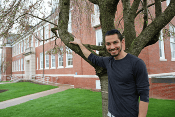 A man standing in front of a tree. 