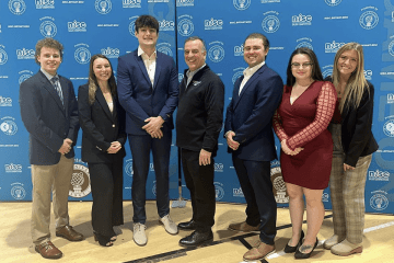 Group standing for a photo in front of a blue wall.