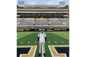 A man standing on a football field. 