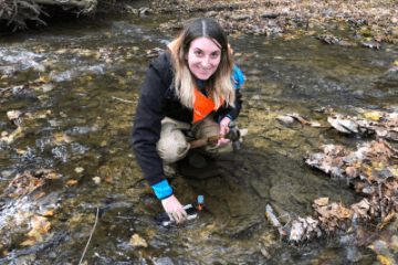Watershed student with hammer in water