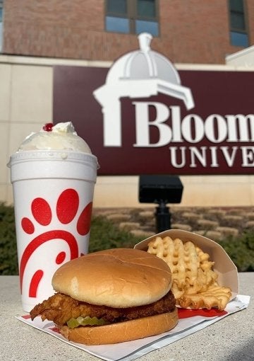 Chick-fil-A sandwich and milkshake in front of Bloomsburg University sign.
