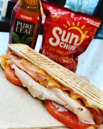Subway flatbread sandwich with Pure Leaf iced tea and Sun Chips.