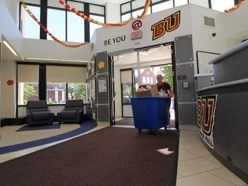 Interior of Columbia Hall entrance with student pushing moving cart