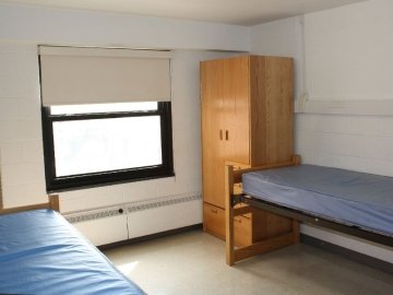 Columbia Hall bedroom showing two beds, a closet and window.