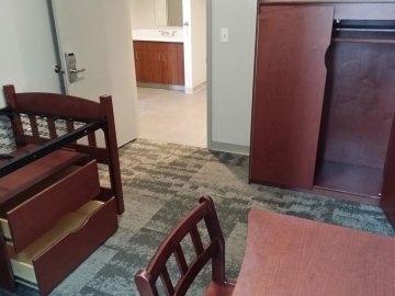 Bed, desk, chair, closet and storage in a bedroom in David Soltz Hall
