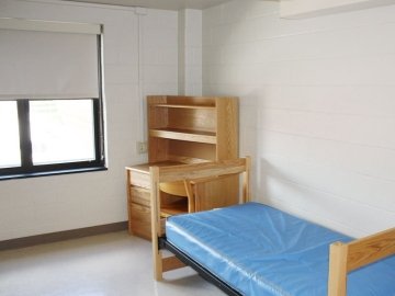 Bed and desk in room of Elwell Hall.