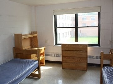 Bedroom in Luzerne Hall showing two beds, a desk and a dresser.