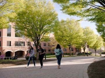 Students walking on tree-lined brick pathway in from of Luzerne Hall