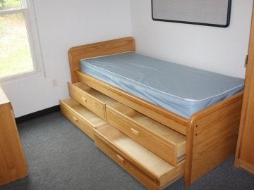 Bed and under bed storage in a bedroom of the Mount Olympus Apartments