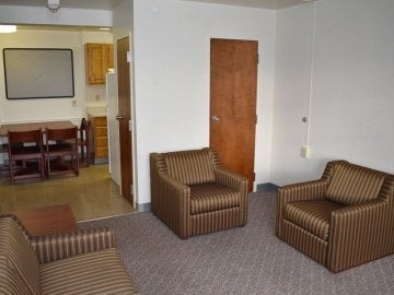 Two chairs, couch, closet and kitchen table in the Montgomery Place Apartments