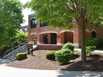 Exterior of Northumberland Hall showing brick pathway, bushes and trees