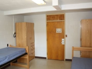Bedroom of Northumberland Hall showing two beds, two closets and the door