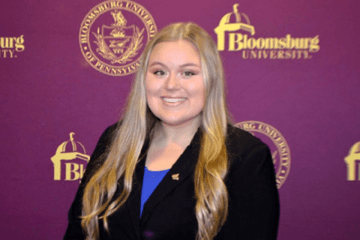 A headshot of a woman in front of a Bloomsburg University background
